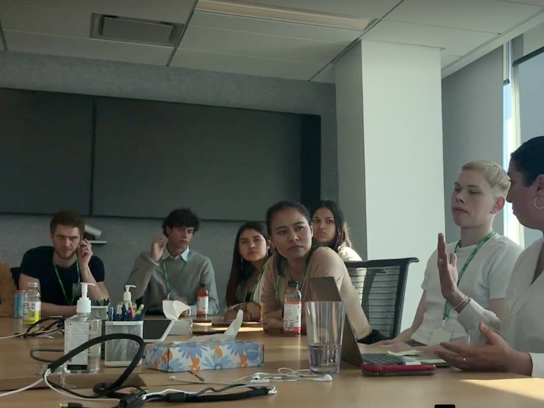 A group of people sitting around a conference table, engaging in a discussion