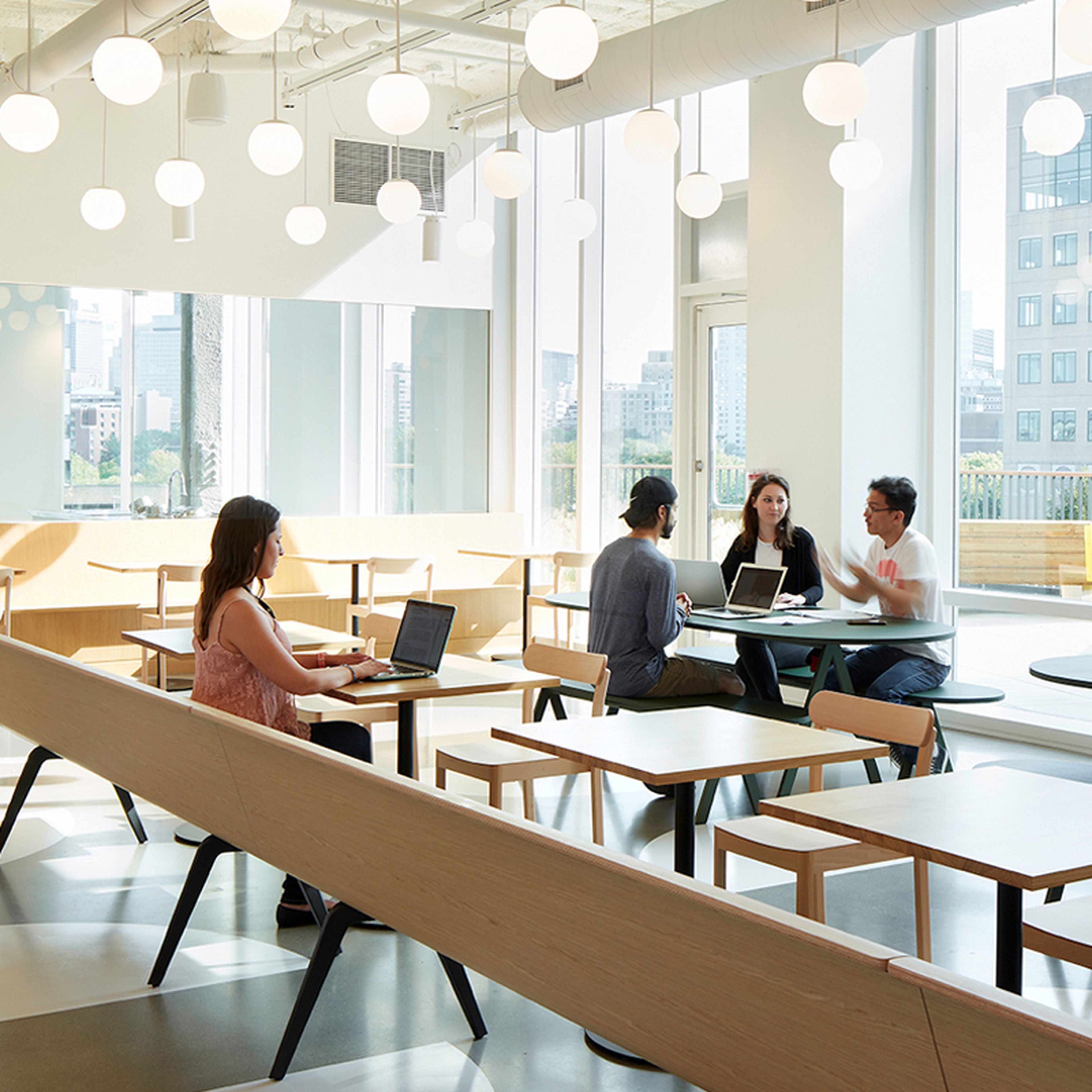 Modern office space with people working and chatting.