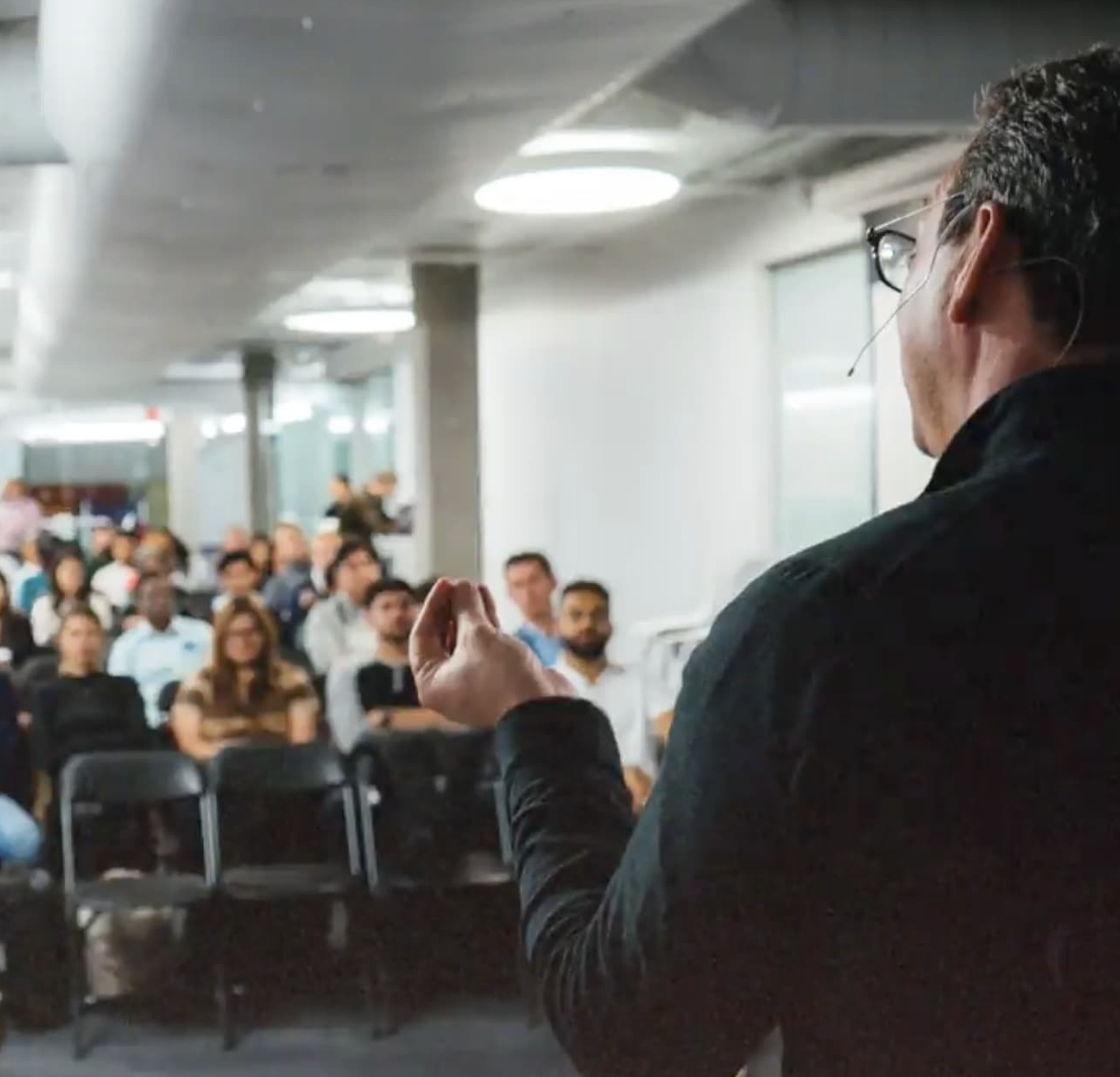 A speaker addressing an attentive audience in a conference room.