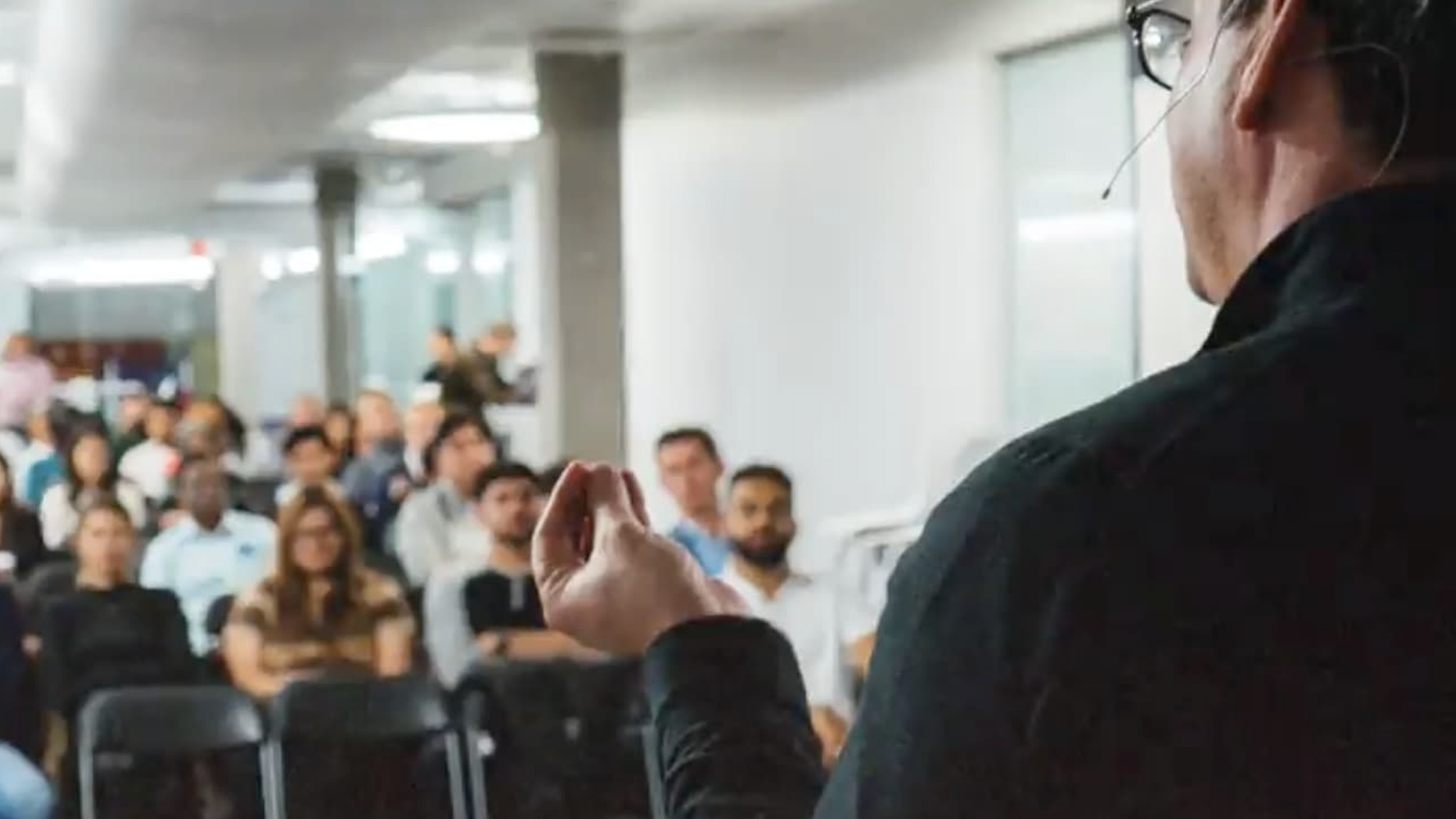 A speaker addressing an attentive audience in a conference room.
