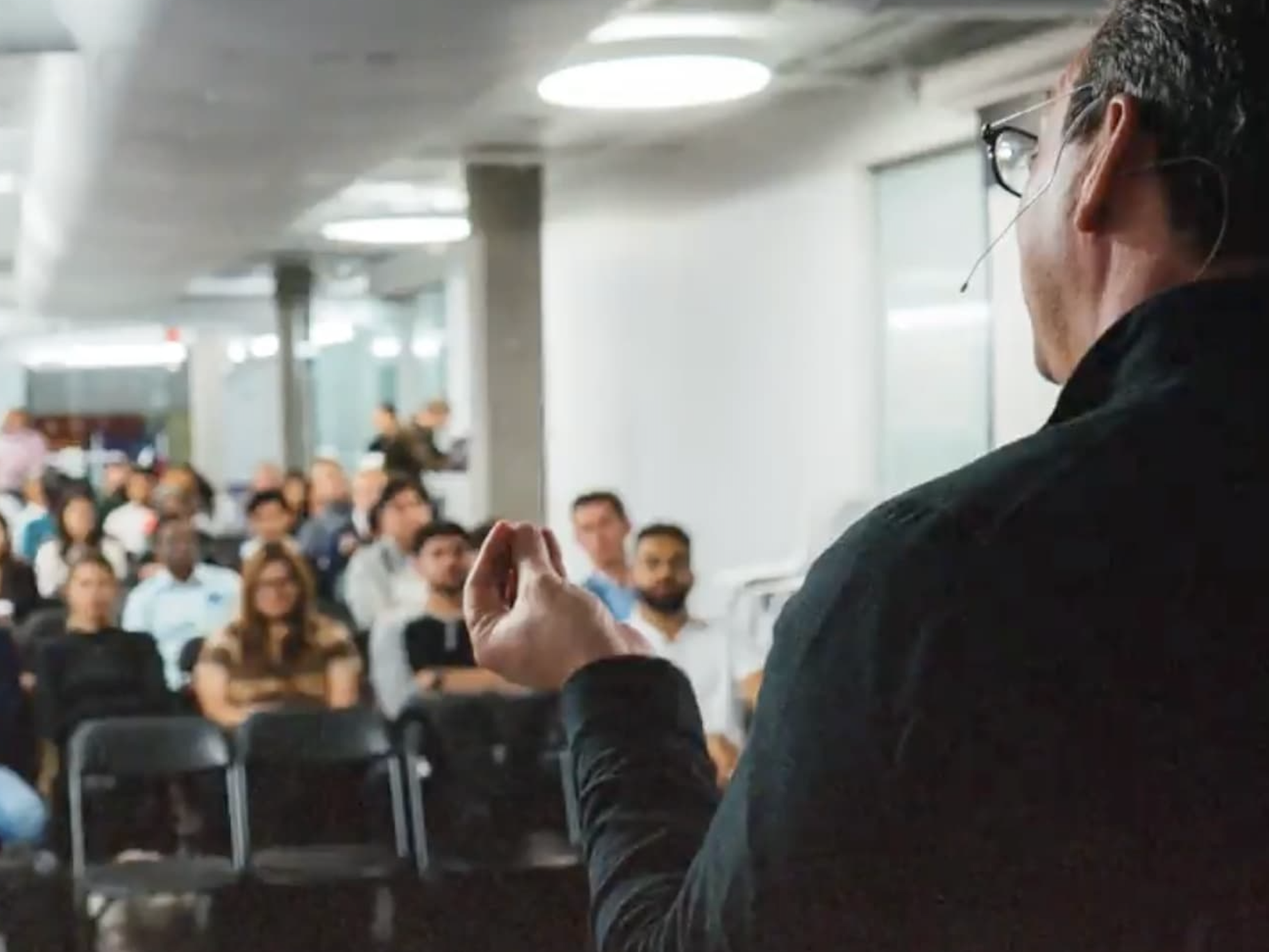 A speaker addressing an attentive audience in a conference room.