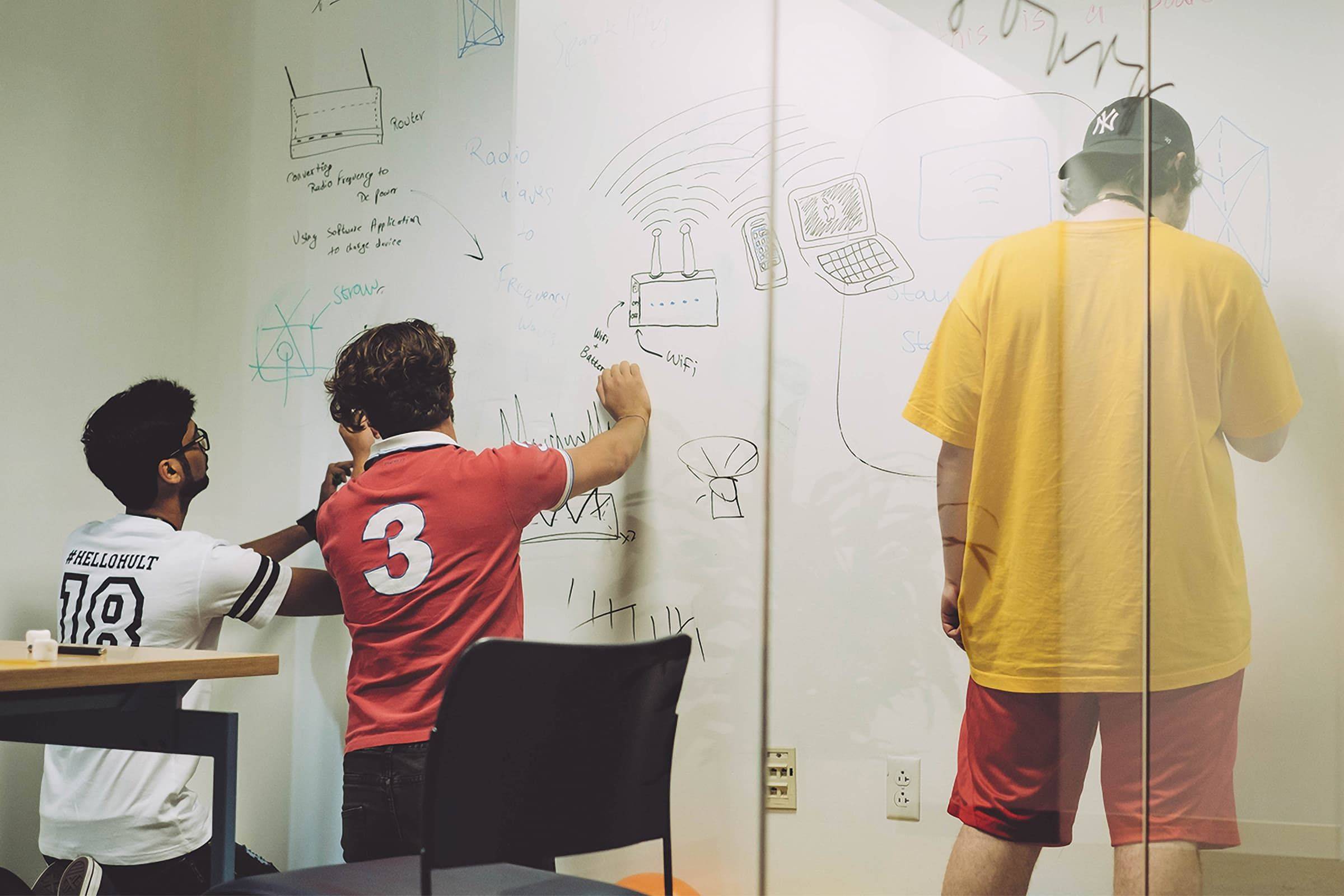 Hult students writing on whiteboard