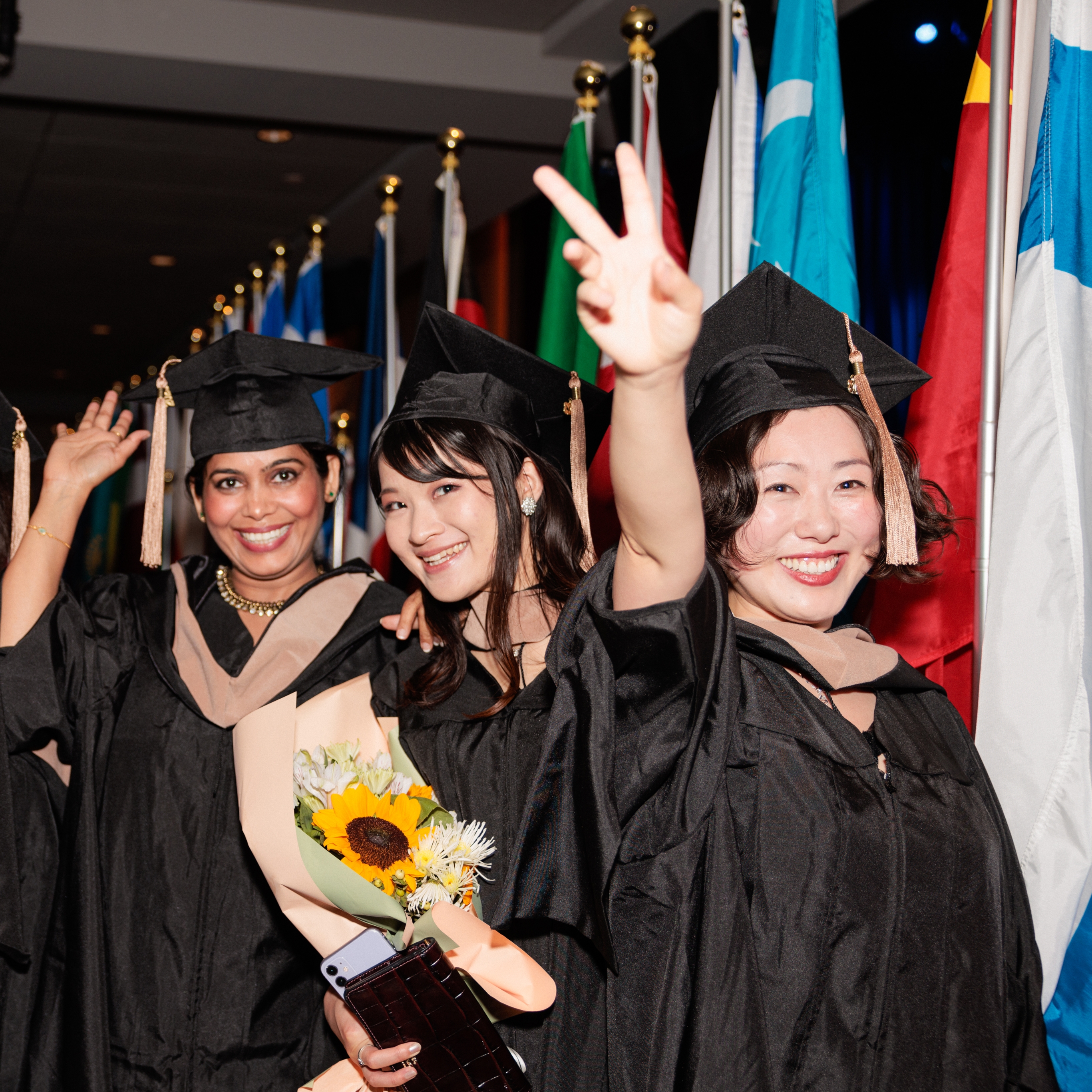 Diverse group of Hult students in front of flags