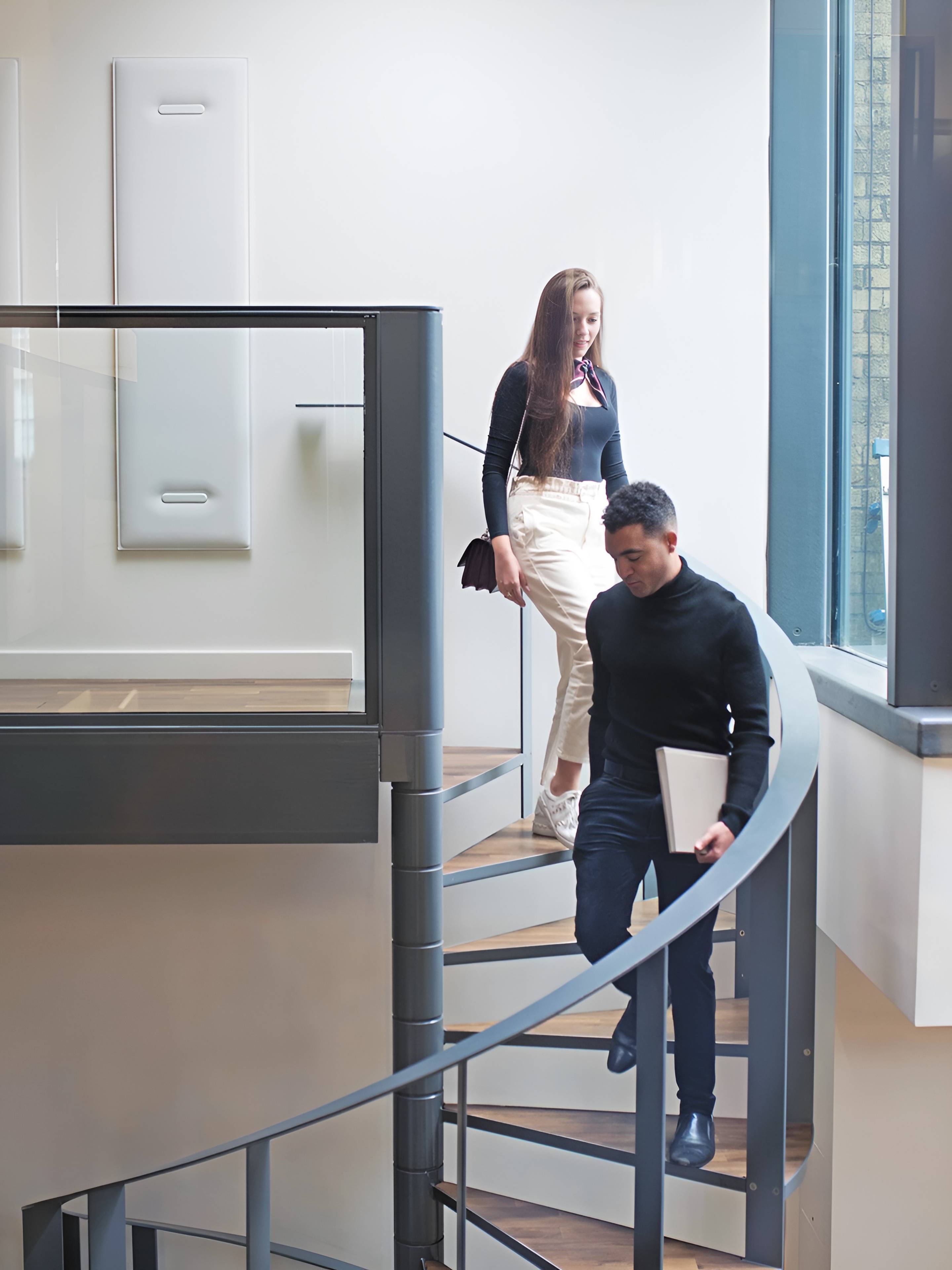 man and woman walking downstairs on campus
