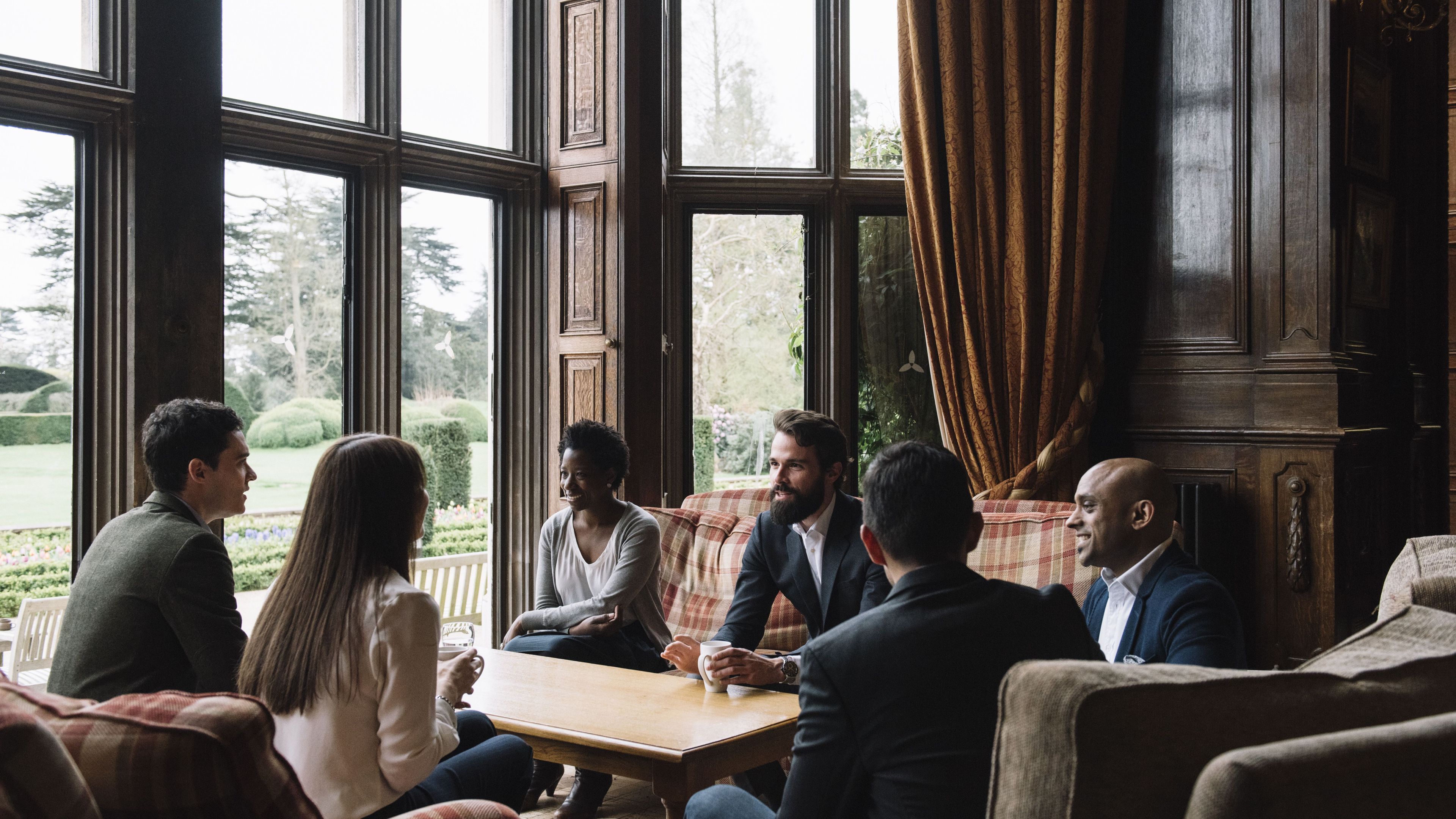 A group of people engaging in conversation inside Hult Ashridge.