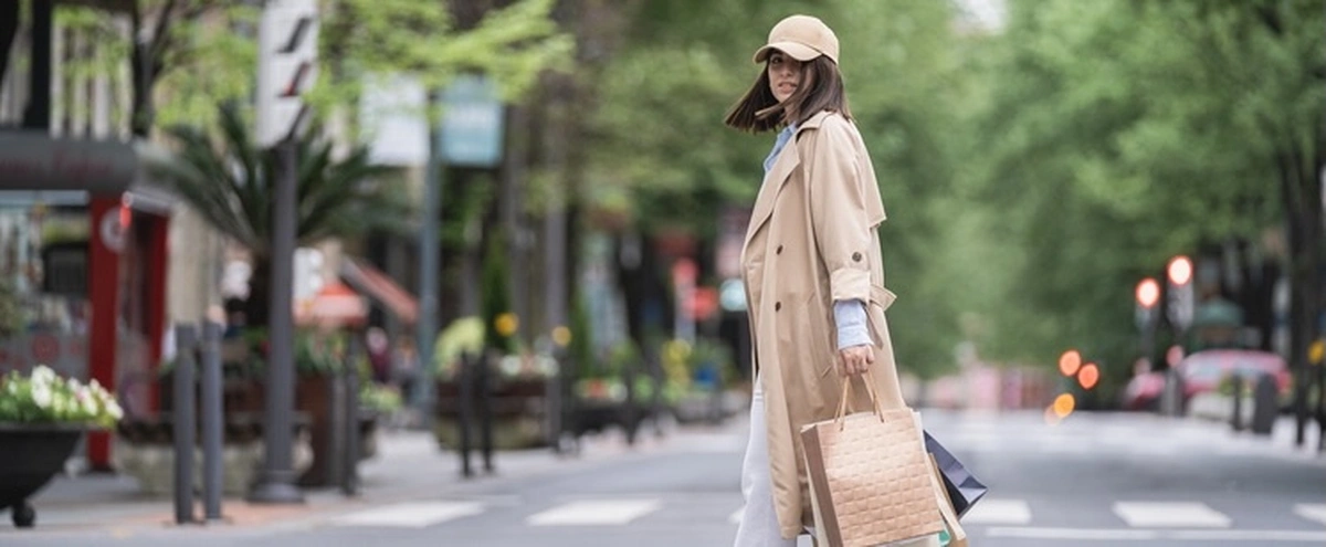 Vrouw met trenchcoat mode fashion shoppen Getty Images 