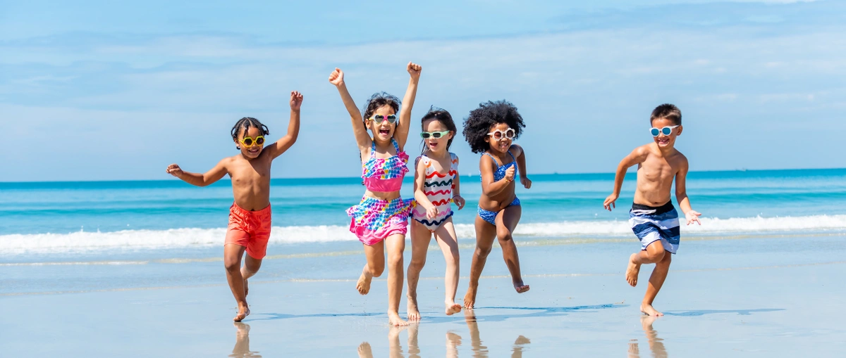 Header - kinderen - vakantie - Shutterstock - vrienden - vriendjes maken - strand - zee - rennen - zonnebril