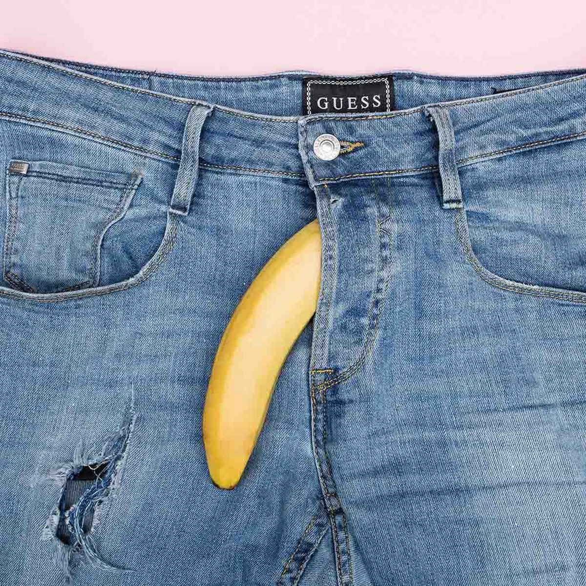 blauwe broek op een roze achtergrond met een banaan uit de gulp