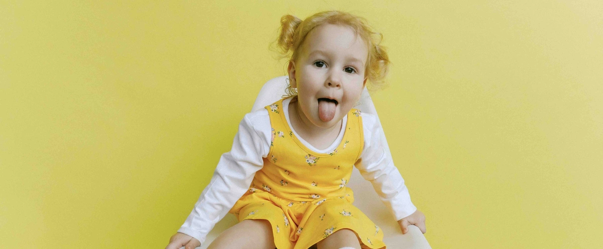 Meisje - jurkje - tong - geel - pexels