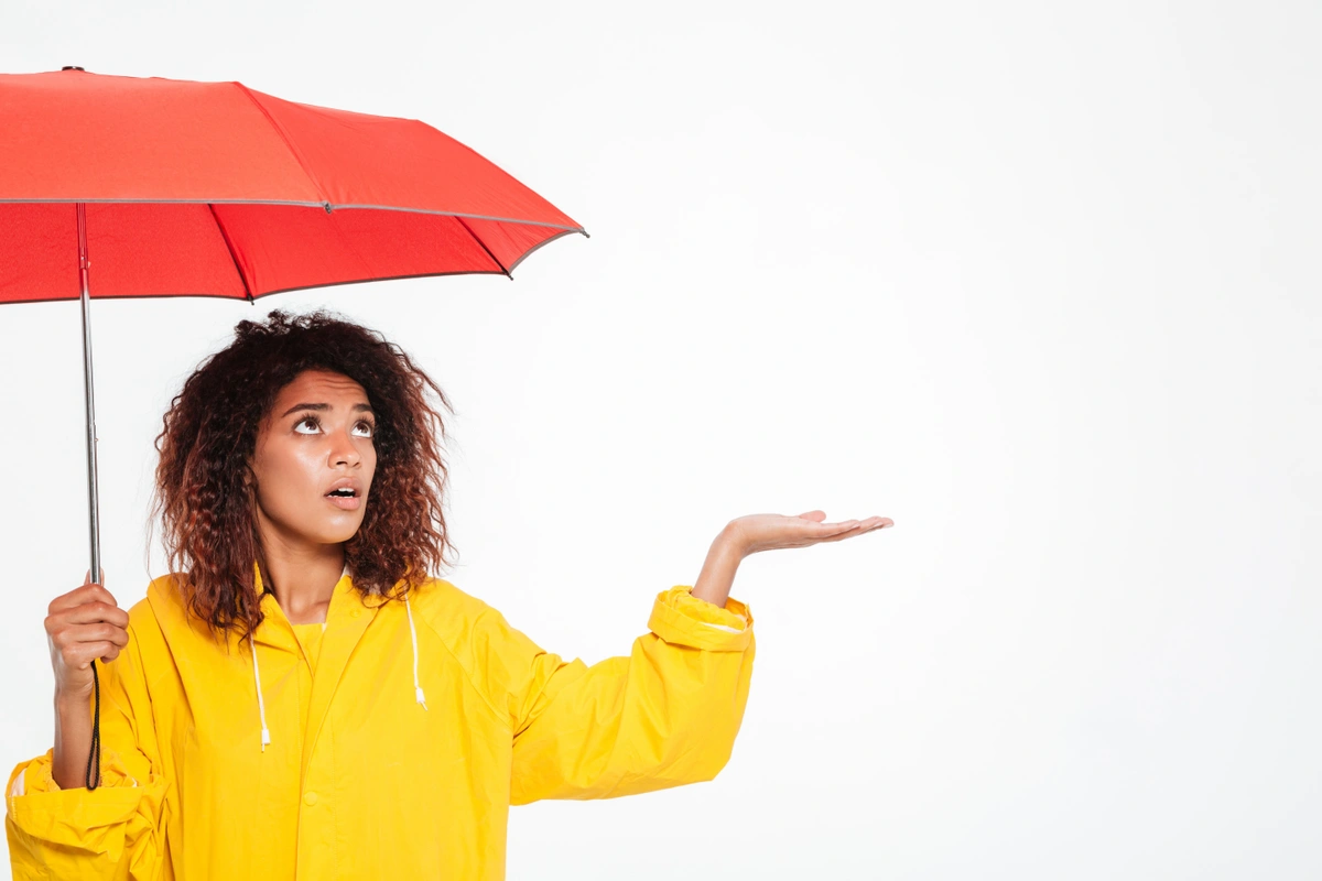 PEXELS-picture-confused-african-woman-raincoat-hiding-umbrella-waiting-raing-white