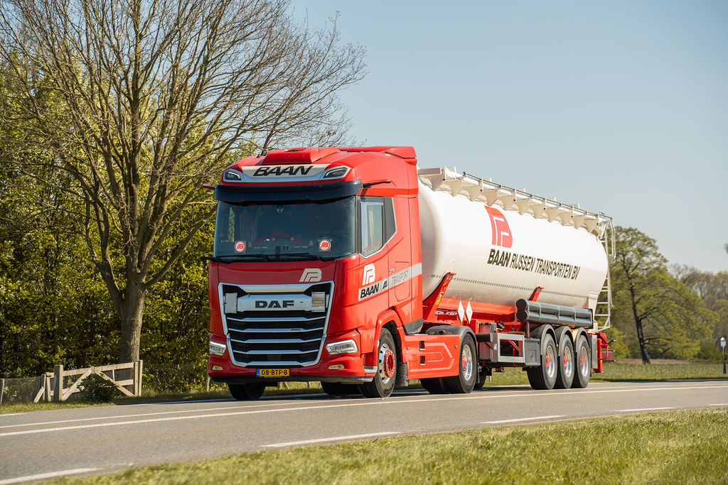 Rode BAAN kiepbulkwagen onderweg op de weg met geknikt dak voor bulkvervoer