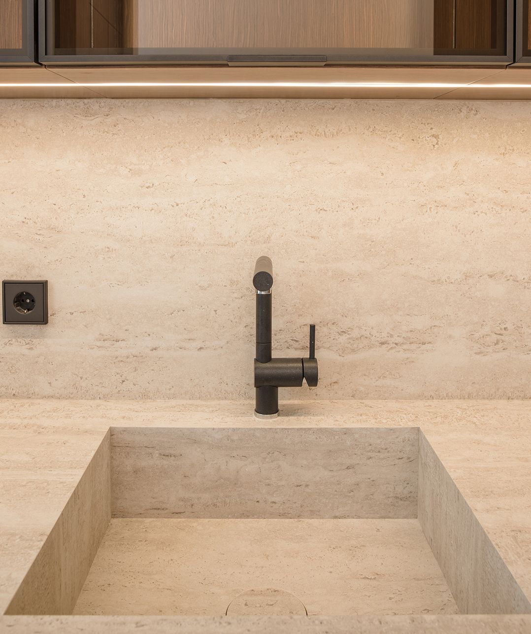 Integrated travertine sink and brown oak cabinetry, Saifi