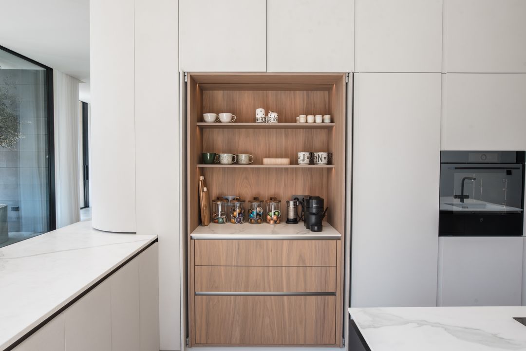 Coffee station behind pocket doors in a frozen walnut kitchen, Cornet Chehwan