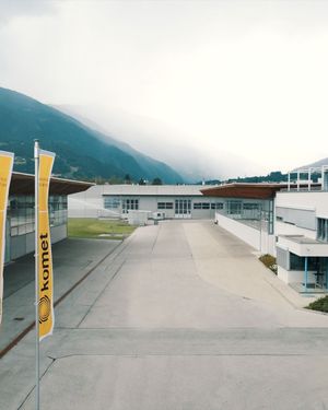 Komet factory building in Lienz with mountains behind