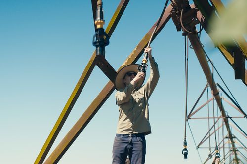 Komet employee mounting a sprinkler on a center pivot span