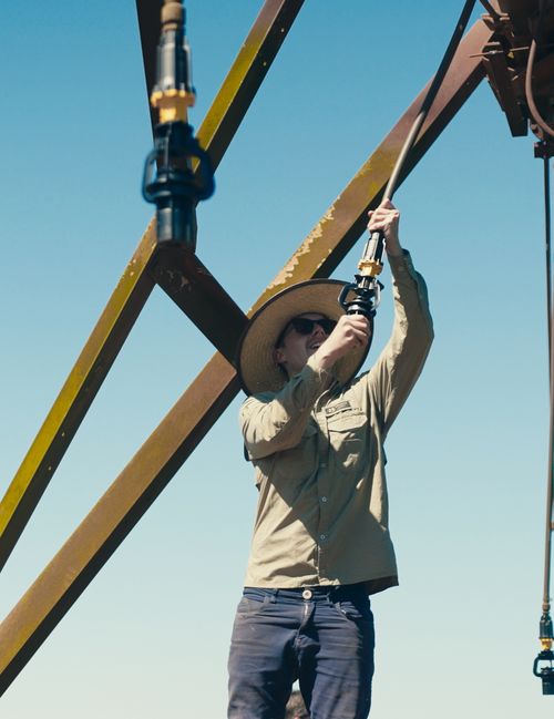 Komet employee mounting a sprinkler on a center pivot span