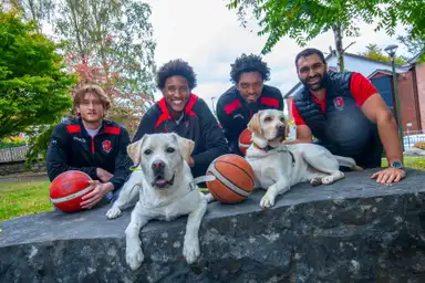 Pictured (l – r) Players Jake Wolfe, Joshua Tomaic and Jordan Rawls with coach Antonio Lopez and Dogs-in-Training Nigel and Monty