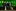 Four men stand in a line with two service dogs in front of a brightly lit green building at night.