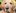 A senior Golden Retriever with a light cream-colored coat and graying muzzle looks directly at the camera with a gentle, calm expression against a blurred green background.