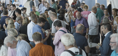Menschen tauschen sich in einem Foyer aus.