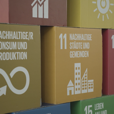 Die Ziele für nachhaltige Entwicklung der UN als bunte Kartons aufeinander gestapelt.