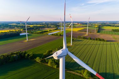 Windräder zwischen grünen Feldern aus der Luft aufgenommen