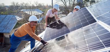 Arbeiter installieren Solarpaneele auf einem Dach