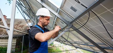 Ein Arbeiter verkabelt Solarpaneele