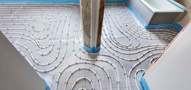 Leitungen für eine Fußbodenheizung in einem Rohbau