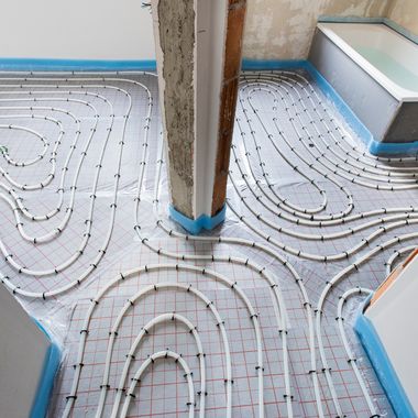 Leitungen für eine Fußbodenheizung in einem Rohbau