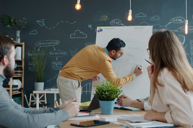 Colleagues discussing ideas at a whiteboard