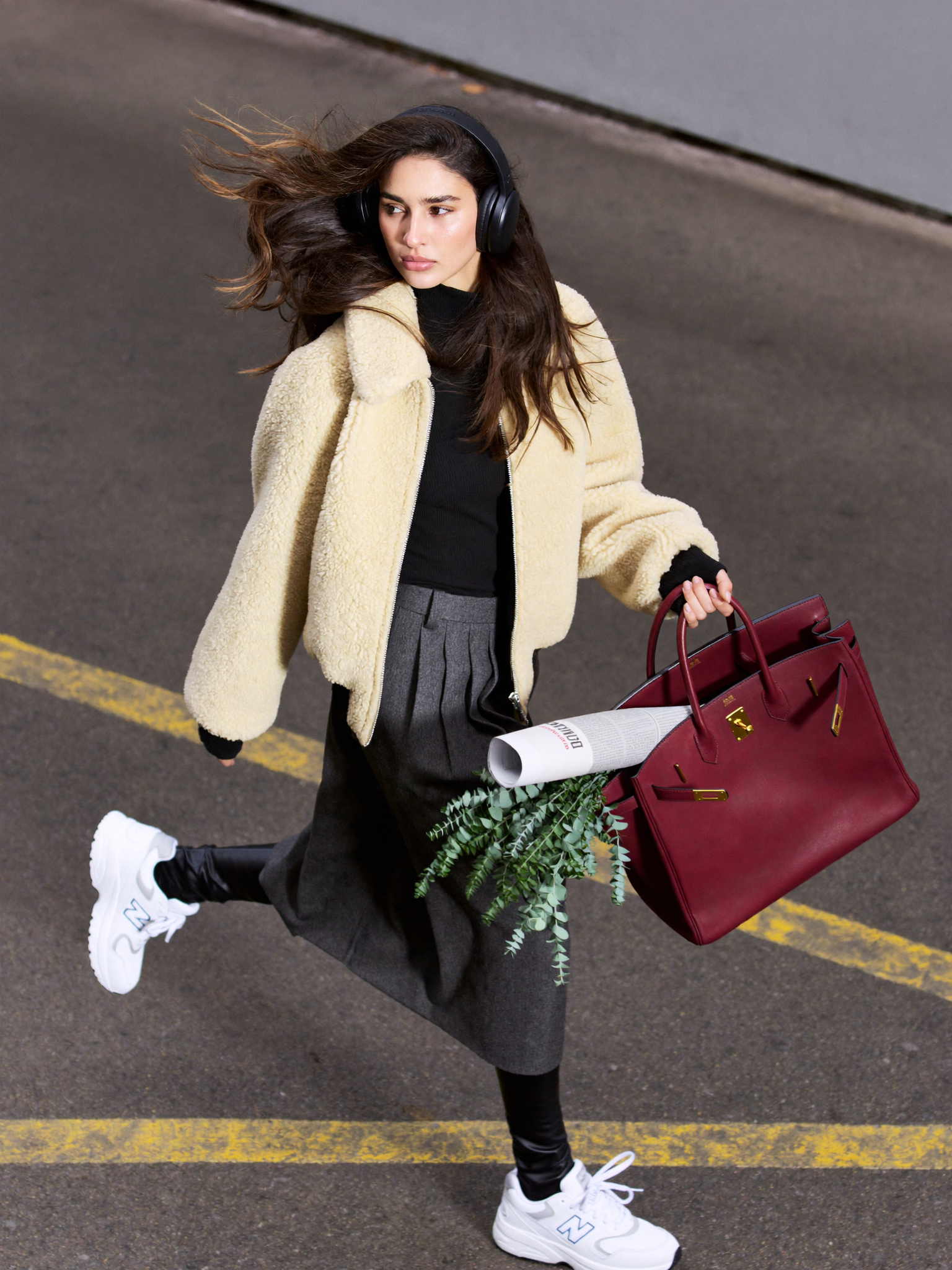 Apply heavy motion blur to entire image, paparazzi street style shot, candid walking motion, dynamic movement smear on hair clothes and bag, slight camera shake, grainy night flash photography aesthetic, blurred face features