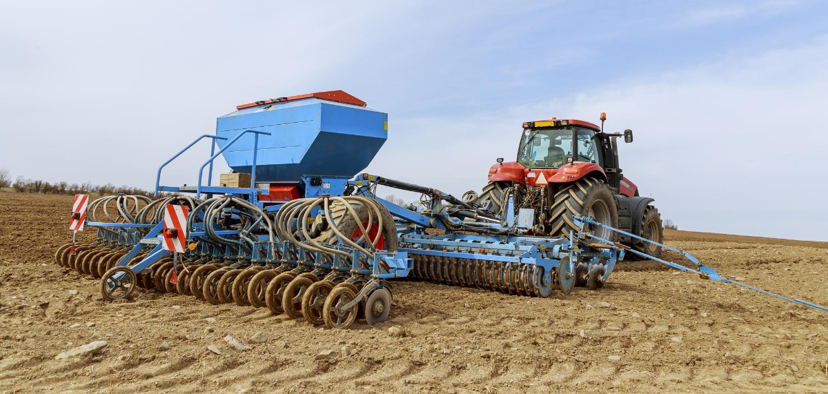 Precision seeder attached to the tractor sowing grain crops in the field
