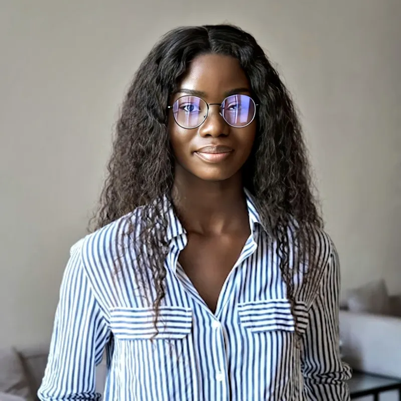 LinkedIn user in striped button-down shirt with glasses, neutral indoor backdrop, representing the Engineering / Technical register