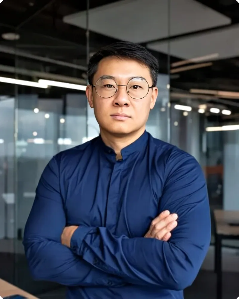 Professional in blazer over open-collar shirt with clean neutral backdrop and soft natural-feel light, representing the Refined Business Casual mode