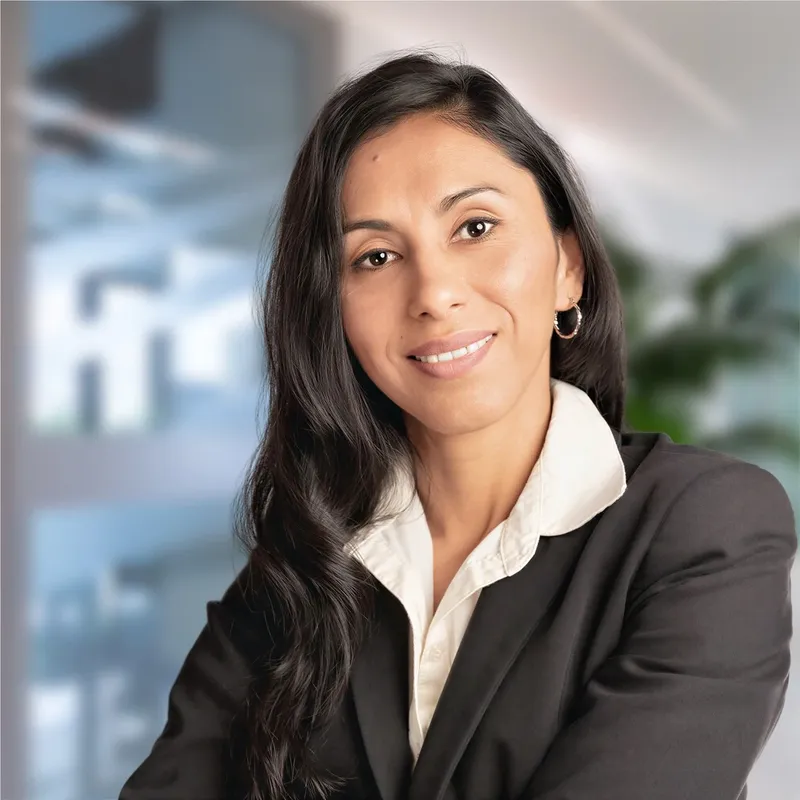 Development leader in a black blazer with a soft office backdrop, representing the photos donors and funders see first