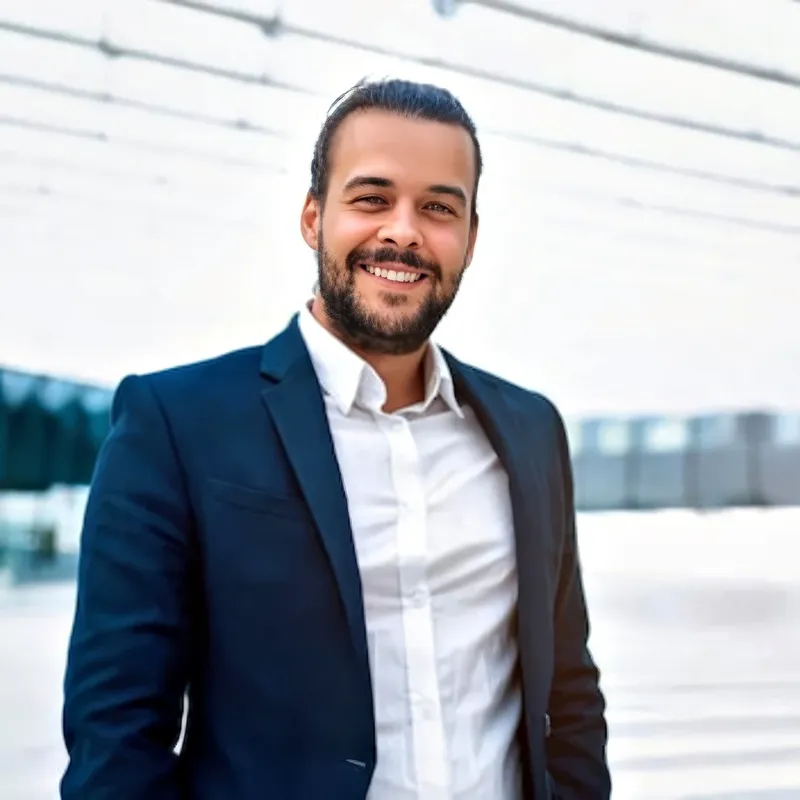 Lawyer in navy blazer with open-collar white shirt, clean modern architectural backdrop, representing the In-House / Corporate attire register