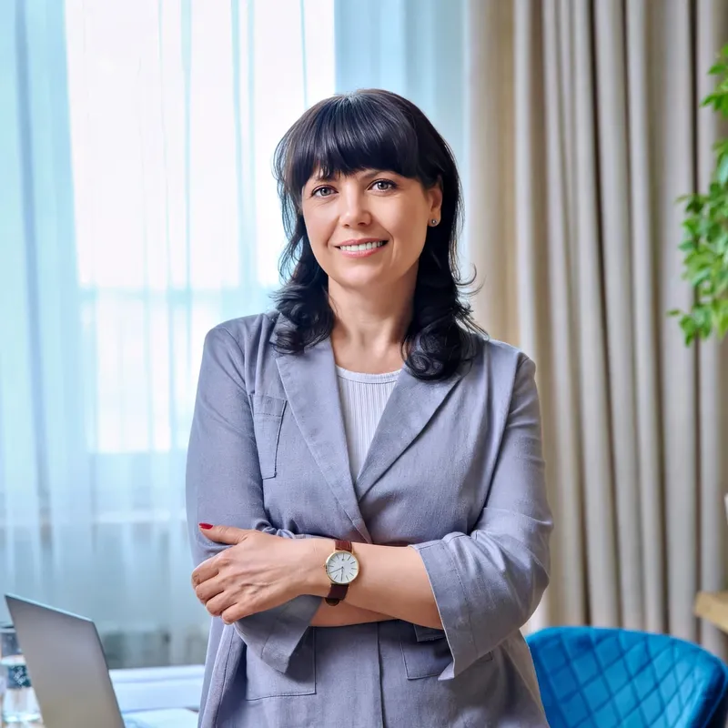 Senior leader in gray blazer, indoor warm professional backdrop, representing the Senior Leader / VP register
