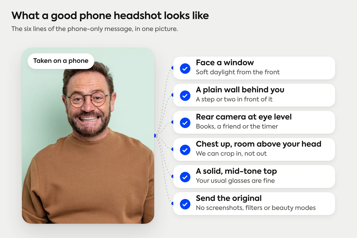 What a good phone headshot looks like: face a window, a plain wall behind you, rear camera at eye level, chest up with room above your head, a solid mid-tone top, and send the original without filters.