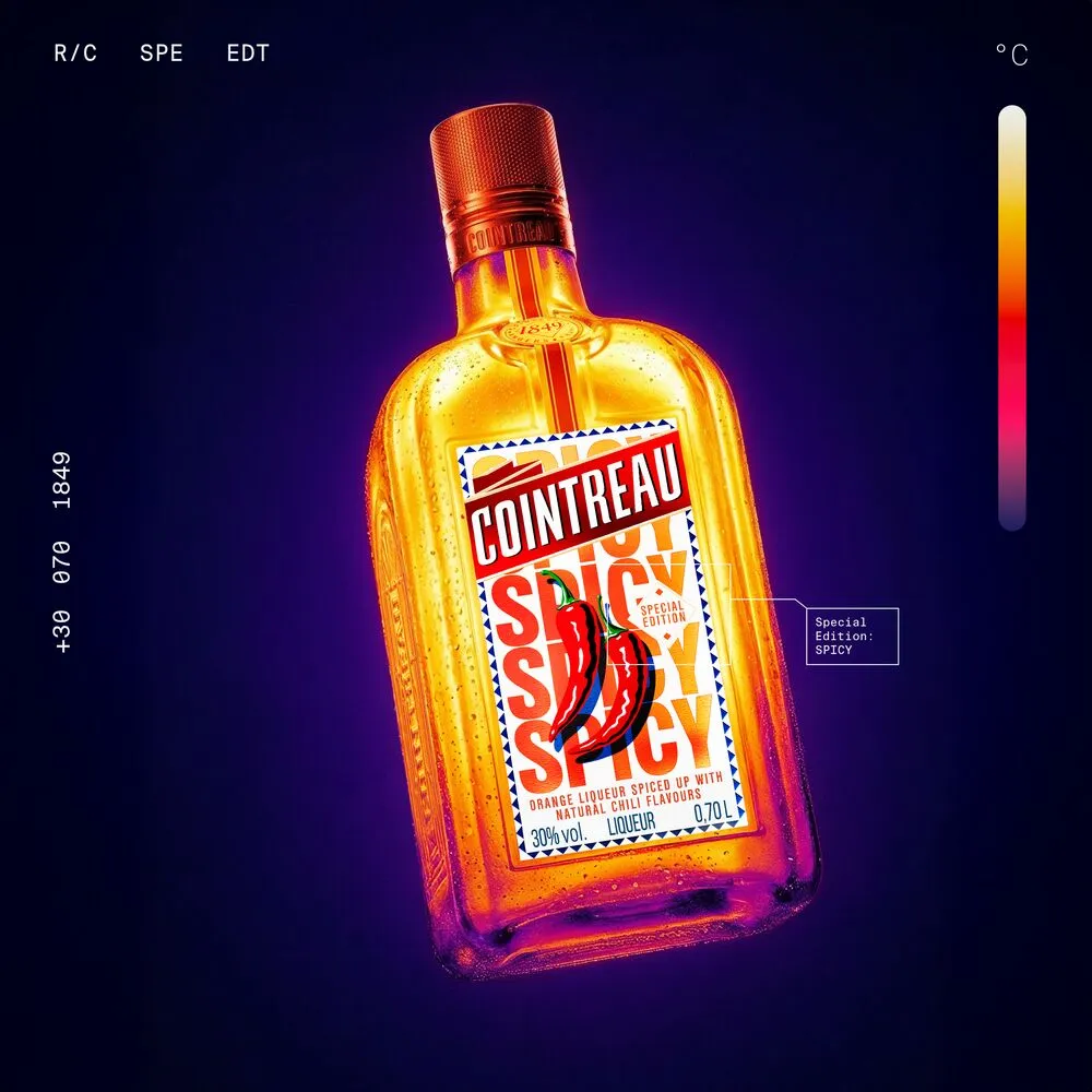 A bottle of Cointreau Spicy in front of a dark violet background