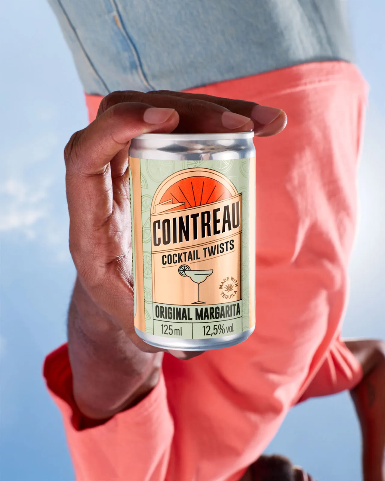 Person holding a can of Cointreau Cocktail Twists upside down