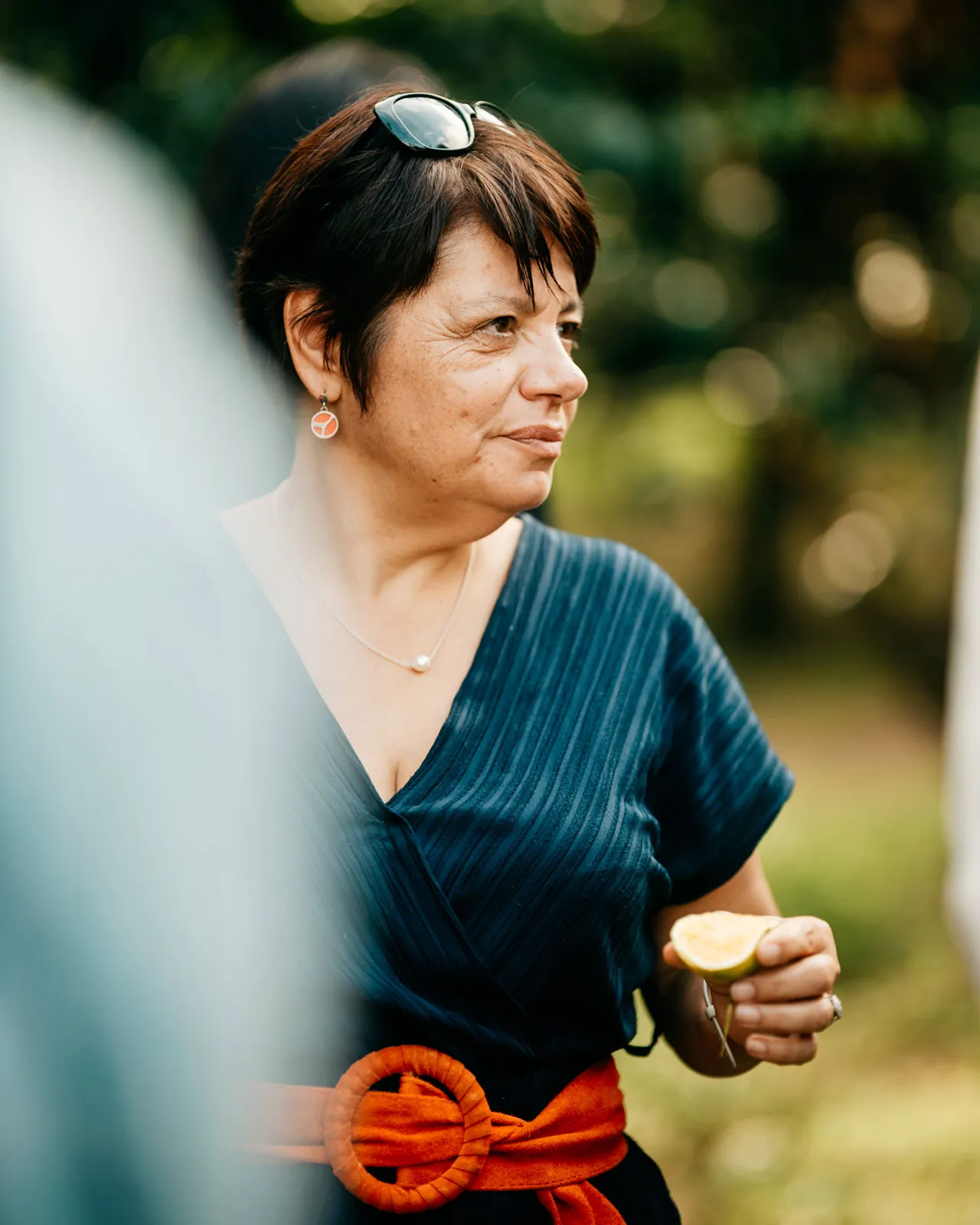 Master Distiller Carole Quinton standing in front of lush greenery