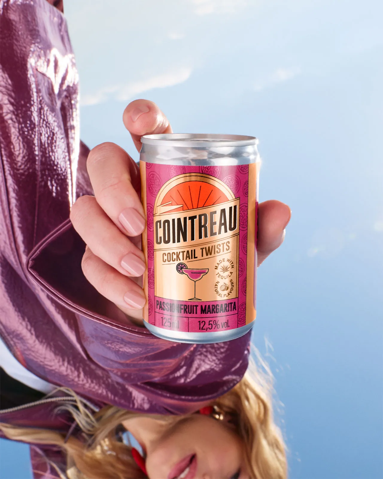 Person holding a can of Cointreau Cocktail Twists upside down