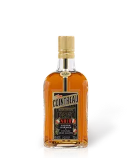 Cointreau Noir orange liqueur bottle, amber glass with golden cap and white label, 700 ml product shot on white background.