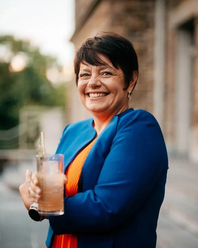 Medium shot of Master distiller Carole Quinton in front of a blurry background with bokeh
