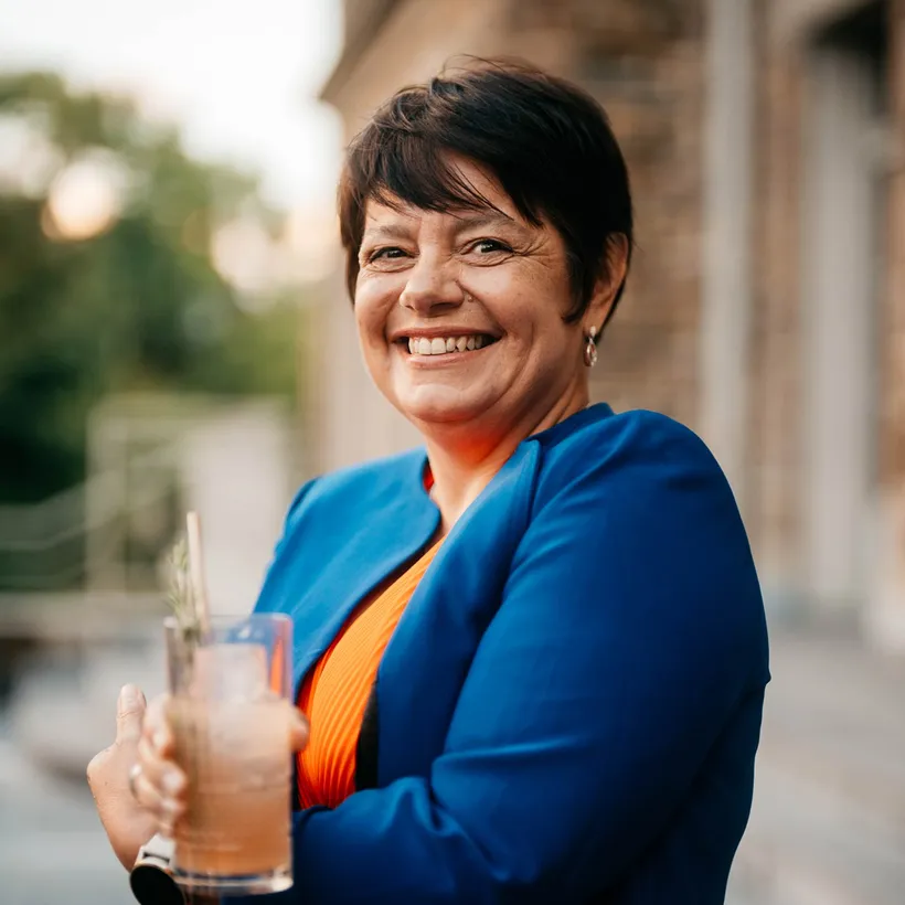 Medium shot of Master distiller Carole Quinton in front of a blurry background with bokeh