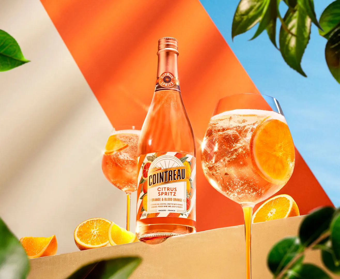 Cointreau Citrus Spritz with two spritz glasses, orange slices and green leaves