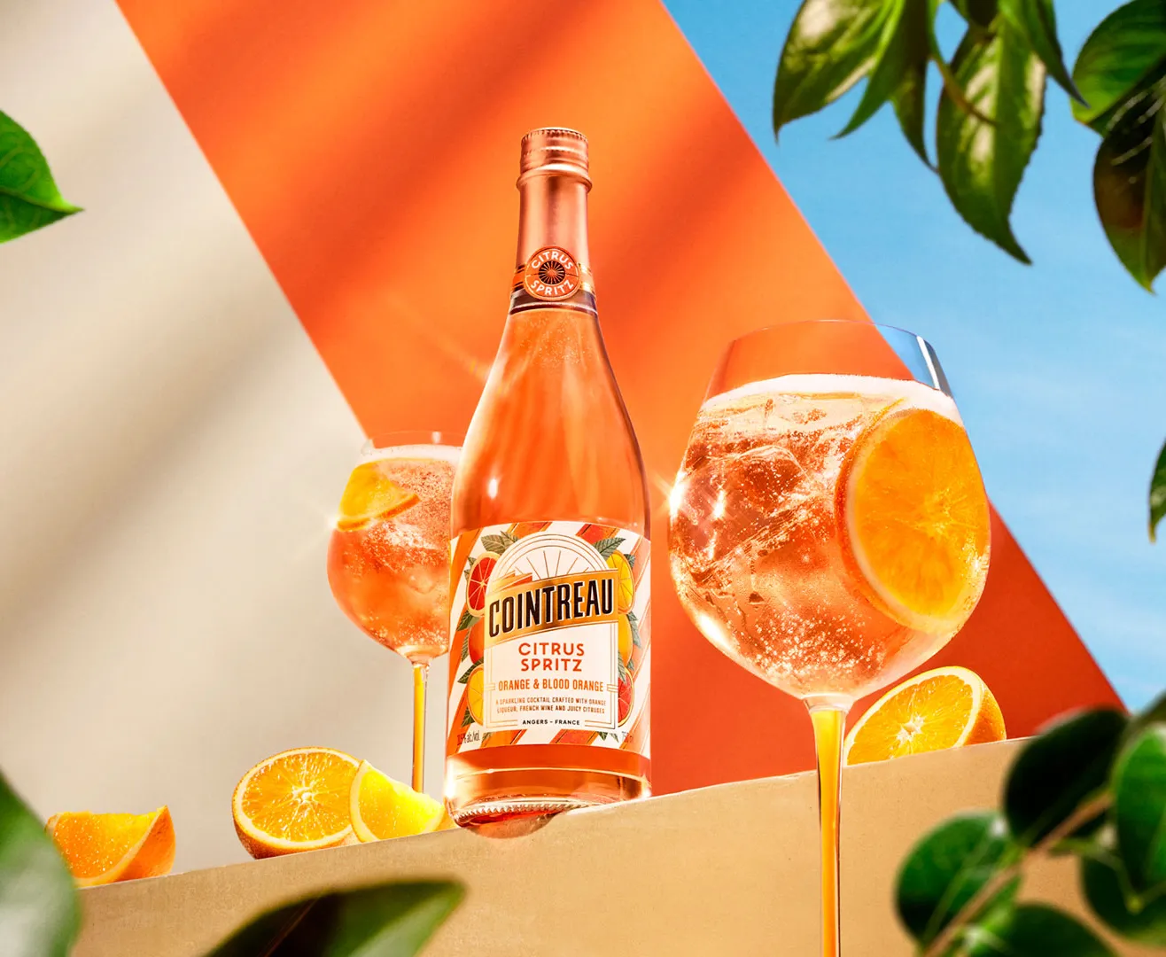 Cointreau Citrus Spritz with two spritz glasses, orange slices and green leaves