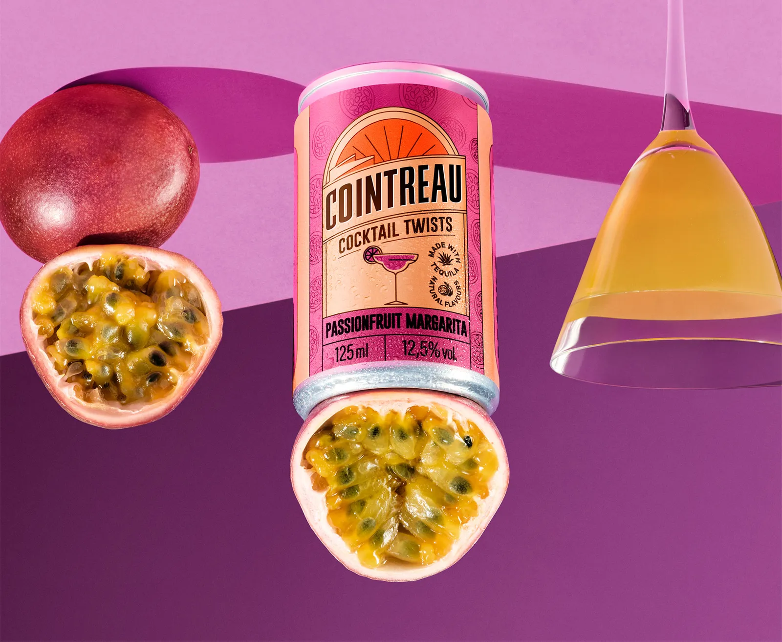 Cointreau Passionfruit Margarita can with fresh passionfruit and cocktail glass on violet background