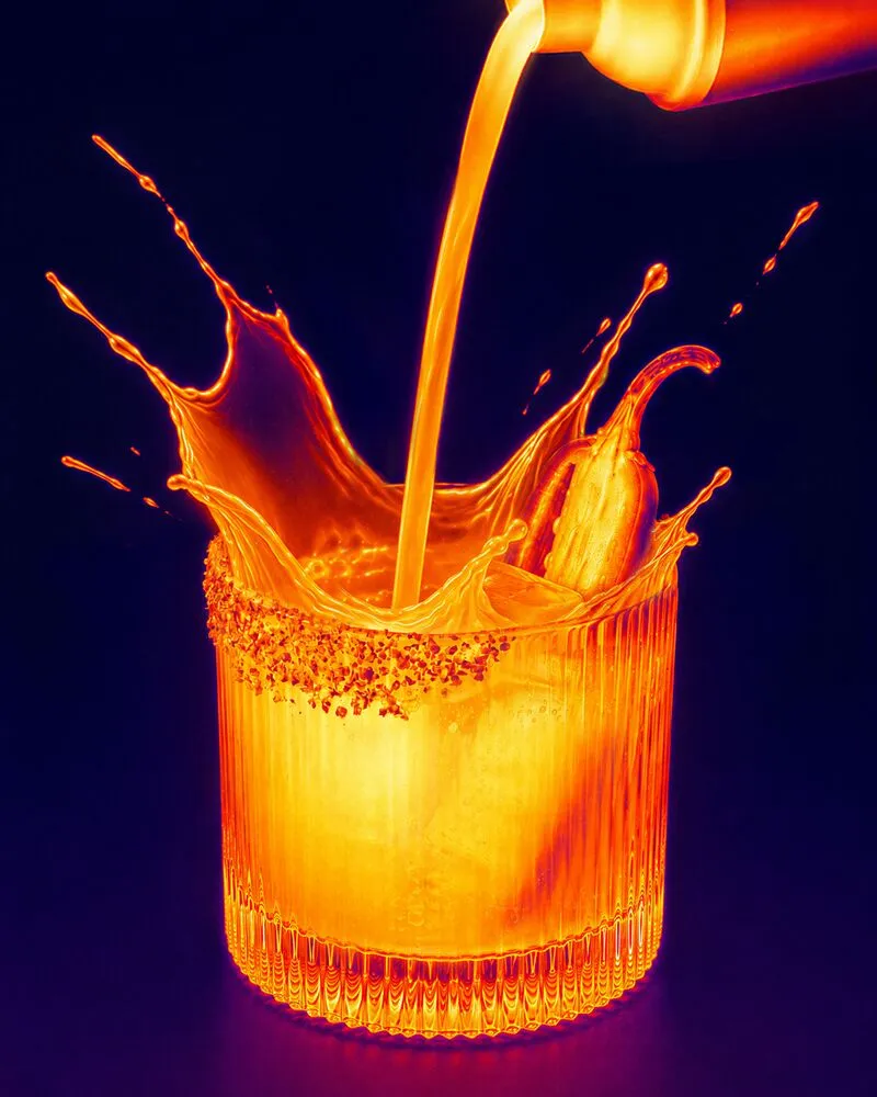 A cocktail poured from a shaker into a cocktail glass, shown in a thermal-style colour gradient